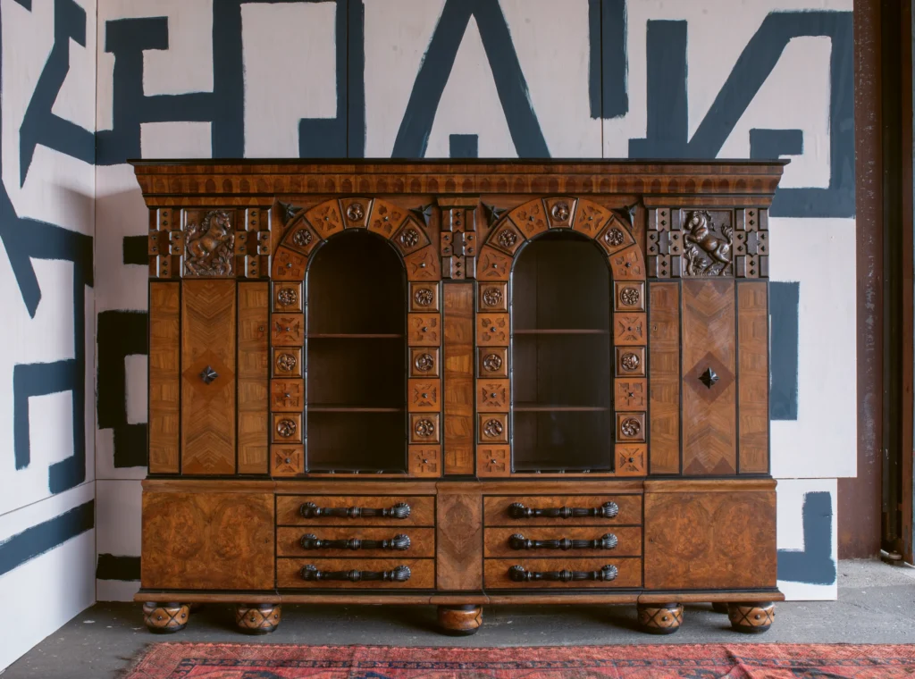 Fritz August Breuhaus

(February 9, 1883–December 2, 1960)

Library cabinet, carved and veneered walnut, veneered amboyna, partly ebonized, manufactured by Valentin Witt, Munich andCologne, circa 1914